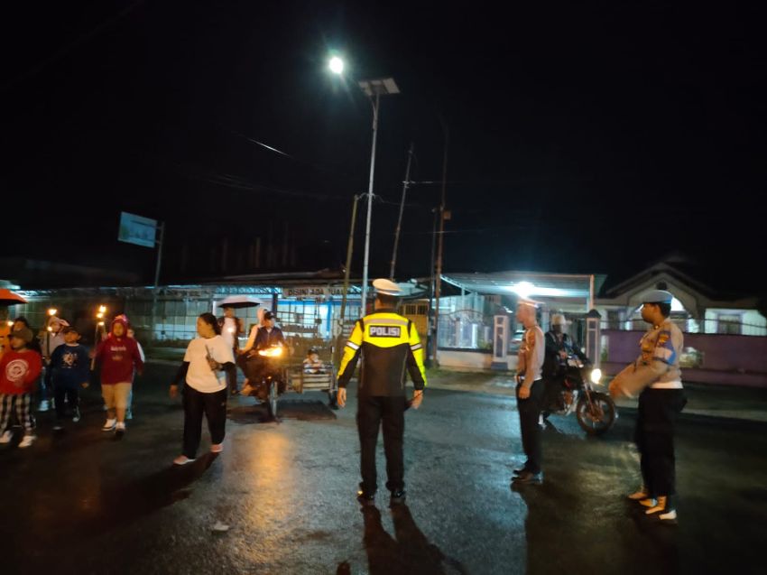 Hujan Tidak Menyurutkan Semangat Polres Tanjung Balai Mewujudkan Keamanan dan Kenyamanan Pawai Obor Paskah Jemaat HKBP Sirantau